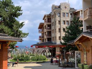 a building with a clock tower on the side of a street at Pirin Golf private studio in Razlog