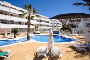 una piscina con tumbonas y un hotel en Azahara Playa 2 - Studio, en Los Cristianos