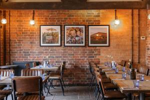 a brick wall with tables and chairs in a restaurant at The Goudhurst Inn in Goudhurst