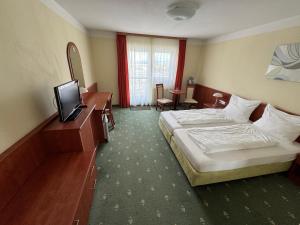 una camera d'albergo con letto e TV di Hotel Breitenlee a Vienna