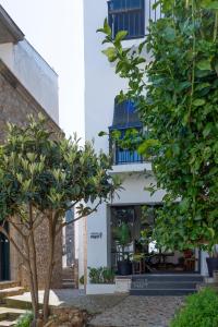 a white building with trees in front of it at Hostal Boutique Es Menut in Tossa de Mar