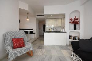 a living room with a chair and a kitchen at Club Atlantis 28 - One Bed in Adeje