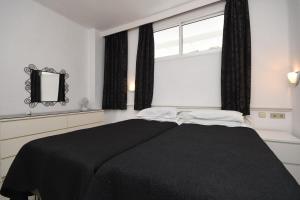 um quarto com uma cama preta e uma janela em Club Atlantis 28 - One Bed em Adeje