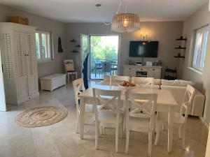 a kitchen and dining room with a white table and chairs at Charming Seaside House next to Beach in Orebić