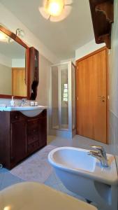 La salle de bains est pourvue d'une baignoire, d'un lavabo et d'un miroir. dans l'établissement Casa Vacanza Presolana con giardino e box auto, à Castione della Presolana