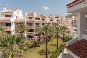 an aerial view of a building with palm trees at Paloma Beach 10 - One Bed with sea view and wifi internet in Los Cristianos