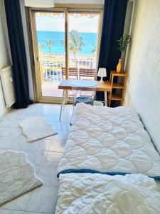 a bedroom with a bed and a table with a view of the ocean at Bella Vista / Appartement vue mer in Nice