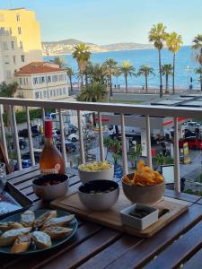 a table with bowls of food on top of a balcony at Bella Vista / Appartement vue mer in Nice