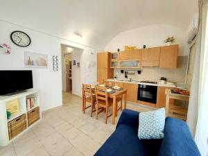 a living room with a blue couch and a kitchen at siciliacasevacanze - Pola Home in Marina di Ragusa