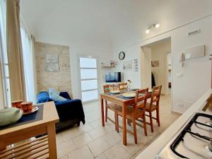 a kitchen and a living room with a table and chairs at siciliacasevacanze - Pola Home in Marina di Ragusa +6 photos