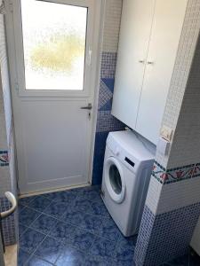 eine Waschmaschine im Bad mit Tür in der Unterkunft Heras house in Ireo