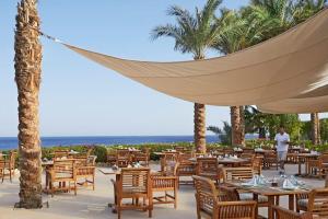 a hammock hanging over a restaurant with tables and chairs at Beautiful villa at Four Seasons in Sharm El Sheikh