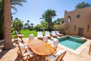 Un patio con mesa y sillas junto a una piscina. en Beautiful villa at Four Seasons, en Sharm El Sheikh 11 fotos más