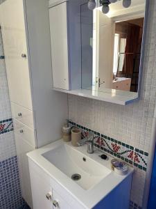 ein Badezimmer mit einem weißen Waschbecken und einem Spiegel in der Unterkunft Heras house in Ireo