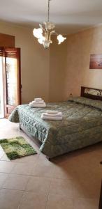 una camera da letto con un letto e asciugamani di Borgo San Giorgio Apartment a Castelmola