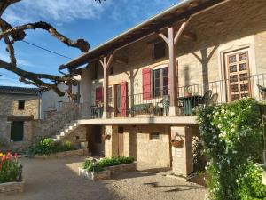 a house with a balcony and red doors at LA PASSIFLORE in Azé