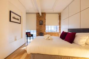 a bedroom with a bed with a teddy bear on it at Central Soho Loft with A C & Concierge in London