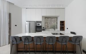 a kitchen with a large kitchen island with black stools at Villa Keshet Eilat in Eilat