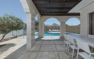 un patio con mesa y sillas y una piscina en Villa Keshet Eilat en Eilat