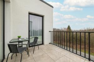 a patio with a table and chairs on a balcony at Cracow Prestigious Family Apartment with Parking Place by Renters Prestige in Krakow