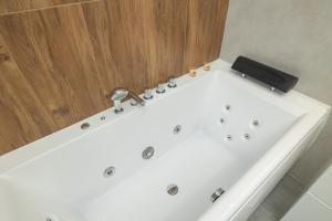 a white bath tub with a faucet in a bathroom at Cracow Prestigious Family Apartment with Parking Place by Renters Prestige in Krakow
