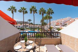 a balcony with a table and chairs and palm trees at Park Santiago II 178 - Two Bed in Playa de las Americas