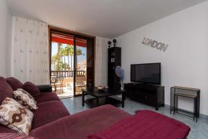 a living room with a couch and a television at Park Santiago II 178 - Two Bed in Playa de las Americas