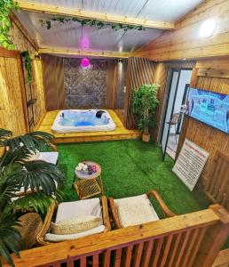 uma banheira de hidromassagem num quarto com relva verde em bali carmel zimmer & spa em Dāliyat el Karmil