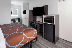a hotel room with a bed and a television at Super 8 by Wyndham Baltimore Northwest in Baltimore