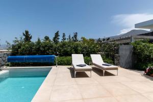 ein Paar Stühle neben einem Pool in der Unterkunft Villa Josefa with private heated pool and lake views in Guía de Isora