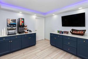 a kitchen with blue cabinets and a flat screen tv at Days-Inn by Wyndham Baltimore Northwest in Baltimore