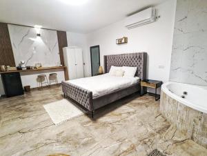 a bedroom with a large bed and a bath tub at bali carmel zimmer & spa in Dāliyat el Karmil