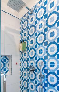 uma casa de banho com uma parede em azulejo azul e branco em Florida Residence em Positano