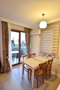 a dining room with a table and chairs and a balcony at Fethiye YALI SUITES in Fethiye