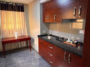 a kitchen with wooden cabinets and a sink and a table at Oakwood Guest House in Palatswe