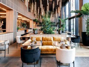 a restaurant with a couch and tables and chairs at Pullman Lyon in Lyon