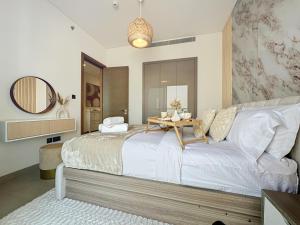 a bedroom with a large bed with a table on it at Key View - Sobha Waves in Dubai
