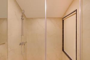 a shower with a glass door in a bathroom at Lemon Tree Hotel, Kasauli in Kasauli
