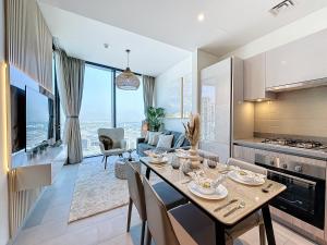 a kitchen and living room with a table and a dining room at Key View - Sobha Waves in Dubai