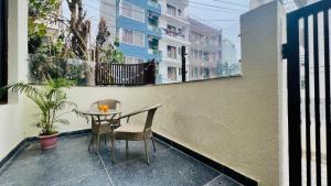 una mesa pequeña y sillas en un balcón con un edificio en BluO Modern 1BHK - DLF Galleria, en Gurgaon