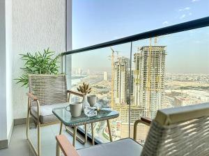a balcony with a table and chairs and a large window at Key View - Sobha Waves in Dubai