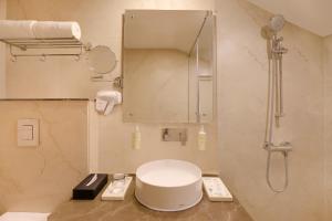 a bathroom with a toilet and a shower with a mirror at Lemon Tree Hotel, Kasauli in Kasauli