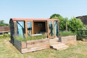 a small house with a wooden deck in a yard at Swallowfield Glamping-Station Master in Yeovil