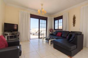 sala de estar con sofá y TV en Playa San Juan 1 - Two Bed Penthouse, en Playa de San Juan