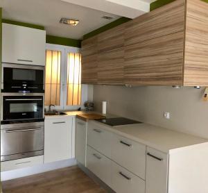 a kitchen with white cabinets and a stove top oven at Apartamento San Gregorio in Pamplona