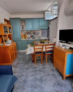 cocina con armarios azules, mesa y sillas en Appartamento La Follicara en Anacapri