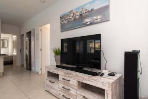 a living room with a flat screen tv on a wall at Villa Clariana in Callao Salvaje