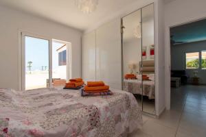 カジャオ・サルバヘにあるVilla Clarianaのベッドルーム1室(オレンジ色の枕が付いたベッド1台付)