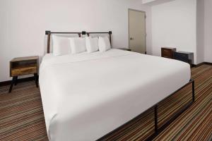 The Herald by LuxUrban في نيويورك: سرير أبيض كبير في غرفة الفندق