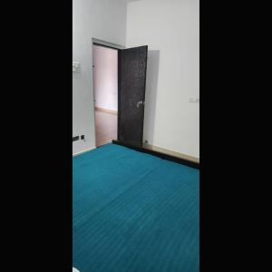 una habitación vacía con una puerta y una alfombra azul en Grand Hotel Inn, en Gaya